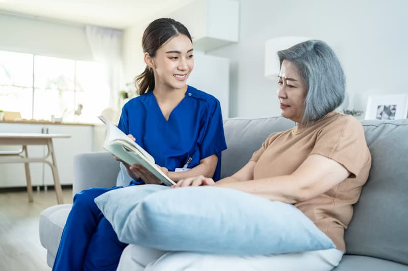 A caregiver smiling beside a senior in a comfortable care setting